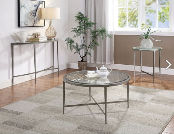 Living room with round glass coffee table, side tables, and decorative items.